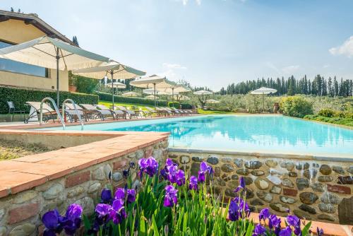 een zwembad met paarse bloemen ervoor bij Borgo Divino in Montespertoli