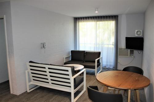 a living room with a couch and a table at Atrium Hotel Mandurah in Mandurah