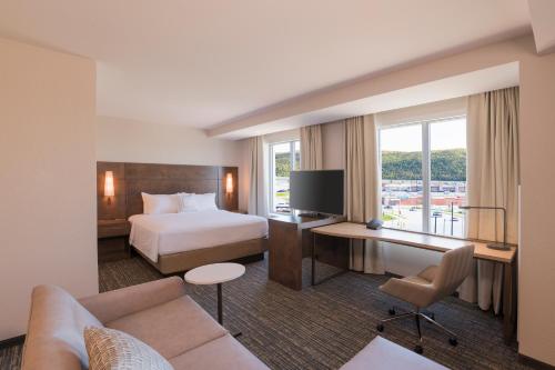 Habitación de hotel con cama y escritorio con TV. en Residence Inn by Marriott Halifax Dartmouth, en Halifax