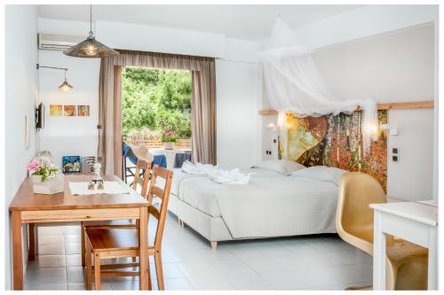 - une chambre blanche avec un lit et une table dans l'établissement Tree of Life Art Hotel, à Agia Marina