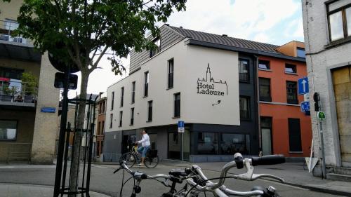 a person riding a bike in front of a building at Hotel Ladeuze in Leuven