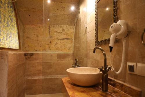 a bathroom with a sink with a shower and a mirror at Hanımkız Konagı in Avanos