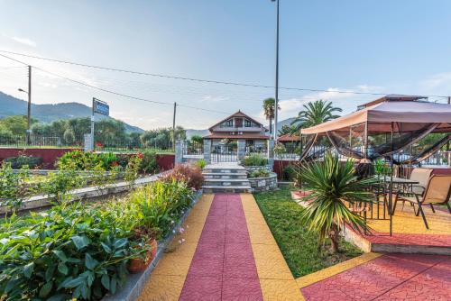 a garden with a house and a red pathway at Katerina Rooms & Apartments in Skala Potamias