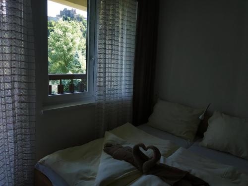 due cigni su un letto in una camera da letto con finestra di Pod hradem Cornštejn a Oslnovice