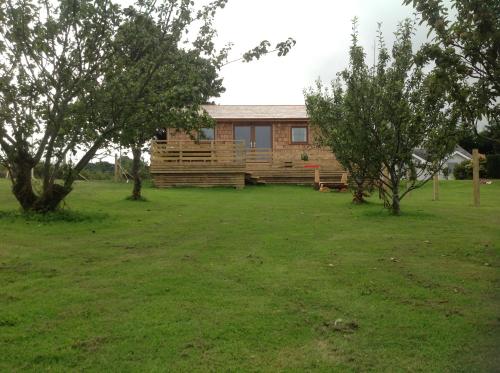 uma casa num campo com árvores à frente em Orme View Lodges em Bangor