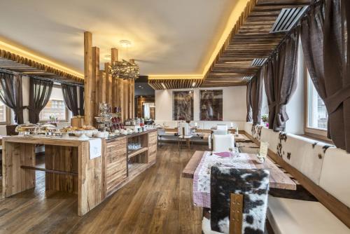 un salone con tavoli e sedie in una stanza di Chalet Vites Mountain Hotel a Canazei