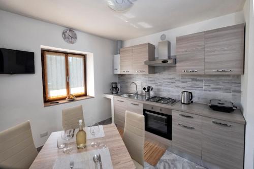 a kitchen with a table with a bottle of wine on it at Casa delle rose in Verbania