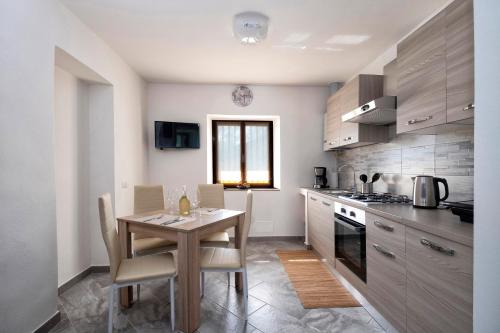 a kitchen with a wooden table and a dining room at Casa delle rose in Verbania