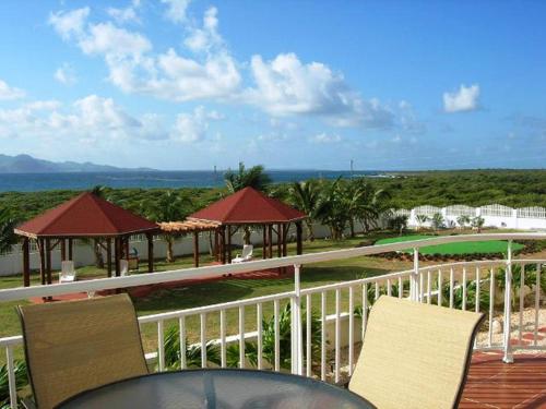 un balcón de un complejo con sillas y un campo de golf en Ocean Terrace Condominiums, en The Valley