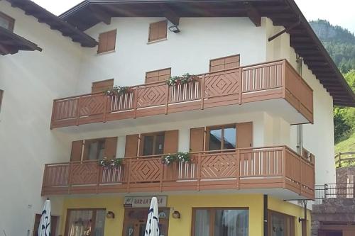 een gebouw met een balkon met bloemen erop bij Chalet La Perla Molveno in Molveno