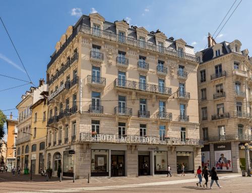 un gran edificio con gente caminando delante de él en Hôtel de l'Europe Grenoble hyper-centre, en Grenoble