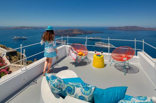 een vrouw op het balkon van een cruiseschip bij Barocco Bello Villa in Fira