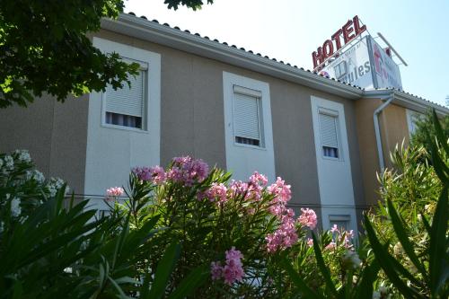 a building with pink flowers in front of it at Hotel Formule Club in Cenon