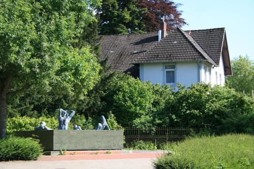 une statue dans un jardin avec une maison en arrière-plan dans l'établissement Ferienwohnung am Kurpark, à Bad Nenndorf