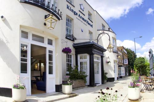 un edificio en una calle con flores delante en The Kings Arms, en Kingston upon Thames