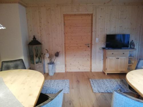 ein Wohnzimmer mit einem TV und Holzböden in der Unterkunft Ferienwohnung Klammhof in Zell am Ziller