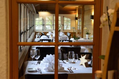 un comedor con mesas blancas y sillas negras en Hotel & Restaurant STERNEN MURI bei Bern, en Berna