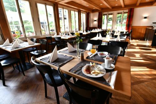 un restaurante con mesas y sillas con comida. en Hotel & Restaurant STERNEN MURI bei Bern, en Berna