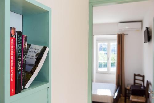 a room with a book shelf with books and a mirror at Takis Family Corfu in Kontokali