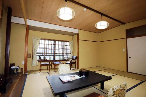 een woonkamer met een tafel en een eetkamer bij Hinode Ryokan in Ise