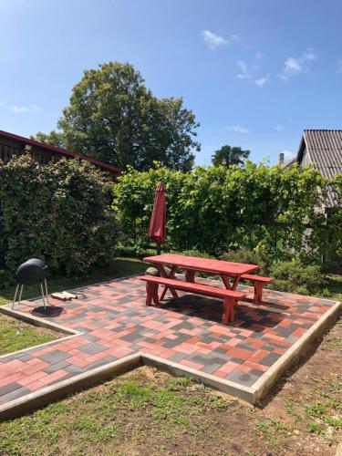 a picnic table and an umbrella on a brick patio at MKA Life in Ventspils