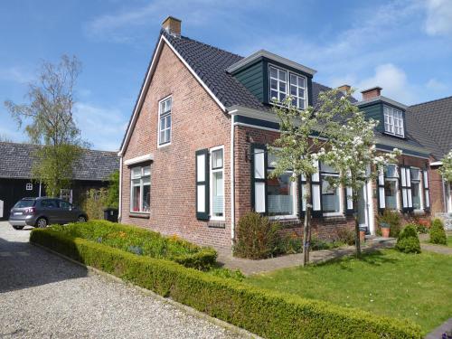 a brick house with a car parked in the driveway at Gastenverblijf Neeltje in Oostkapelle