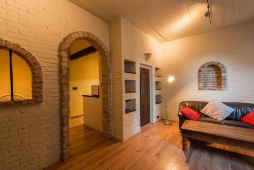 a living room with a couch and a brick wall at City Flats by Lybeer Hotel Group in Bruges