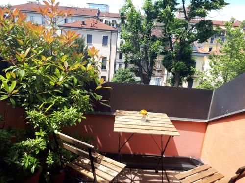 a small wooden table and bench on a balcony at Teodora B&B in Milan