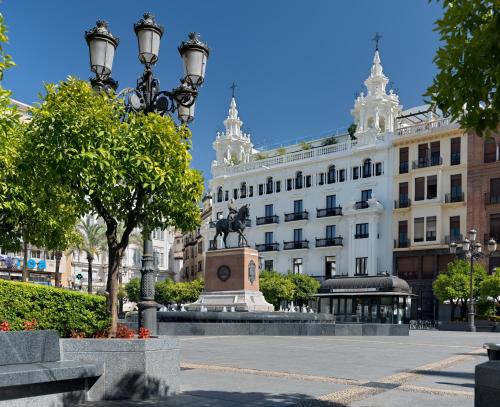 um edifício com uma estátua no meio de uma rua em H10 Palacio Colomera em Córdoba