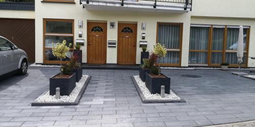 um edifício com três vasos de plantas à sua frente em Fewo Rheinwein 1 "ausgezeichnet zum wandern und radfahren" mit Wallbox em Boppard