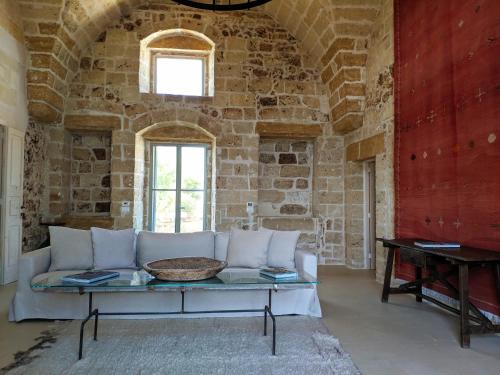 a living room with a white couch in a stone wall at Masseria Trapana in Lecce