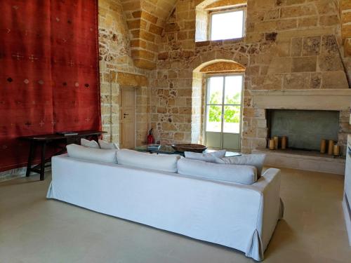 a living room with a white couch and a fireplace at Masseria Trapana in Lecce