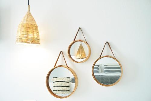 three mirrors hanging on a wall with towels at Galini Hotel in Naxos Chora