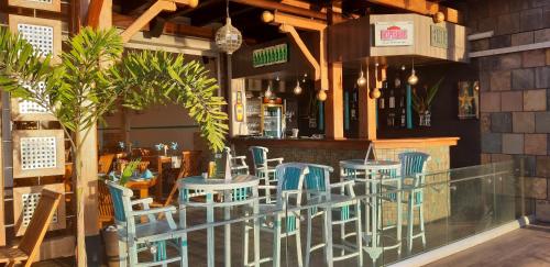 een restaurant met blauwe stoelen en een bar bij Azure Beach Boutique Hotel in Grand Baie