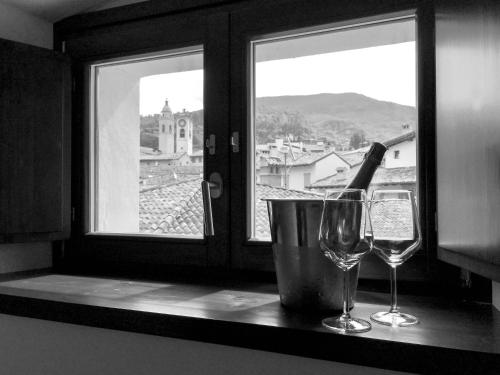 two wine glasses sitting on a counter with a window at La Corte Room & Relax in Rovereto