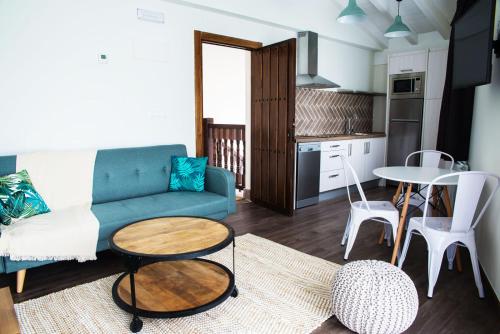 a living room with a couch and a table at Apartamentos Estela de Altamira in Santillana del Mar