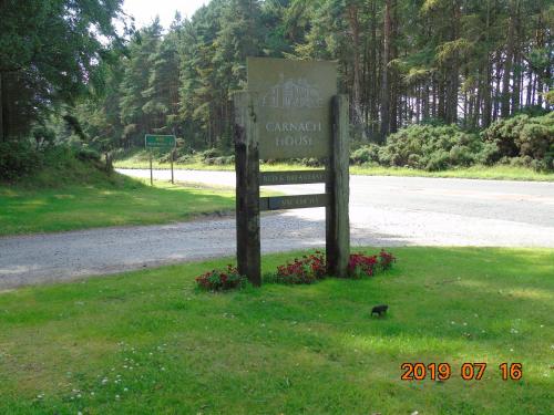 un panneau dans l'herbe à côté d'une route dans l'établissement Carnach House, à Nairn