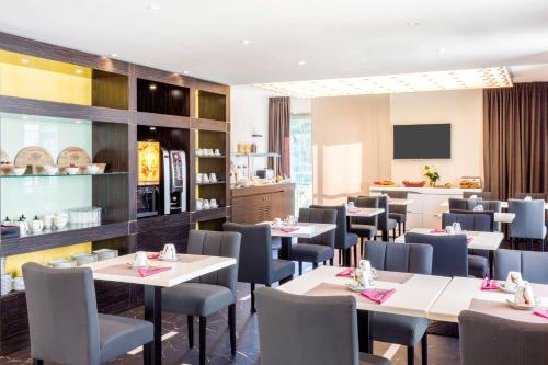 een restaurant met tafels en stoelen en een keuken bij Best Western Hôtel Journel Antibes Juan-les-Pins in Antibes