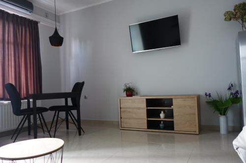 een woonkamer met een tv en een tafel en stoelen bij Studio apartmani Vinica in Vinica