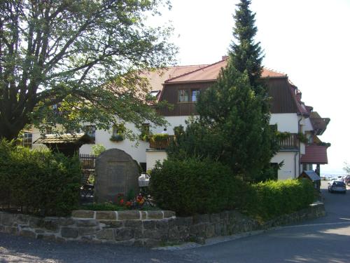 a white house with a tree in front of it at Rübezahlbaude in Großschönau