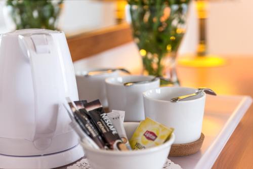 un groupe de tasses blanches assises sur une table dans l'établissement AirPark Balice, à Balice