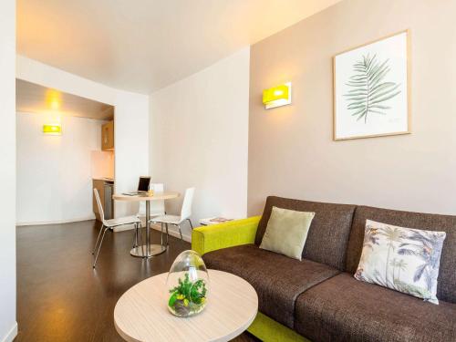 sala de estar con sofá y mesa en Aparthotel Adagio Access Paris Reuilly, en París