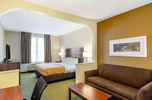 una camera d'albergo con letto e divano di Quality Inn & Suites Near Tanger Outlet Mall a Gonzales