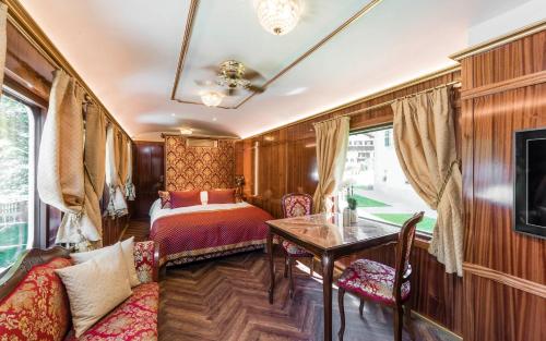 カンポ・ディ・トレンスにあるLuxury Lodge - Orient Express Lenerのベッドとテーブルが備わる列車室