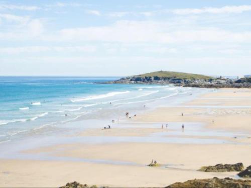 un groupe de personnes sur une plage avec l'océan dans l'établissement Bambu Cottage, à Newquay