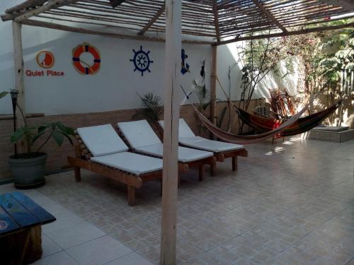 un patio con 2 sillas y una hamaca en Paracas Backpackers House, en Paracas