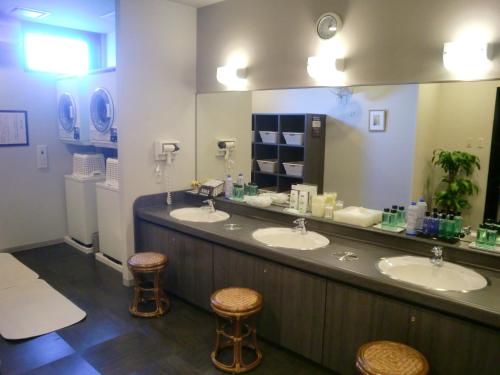 baño con 2 lavabos y espejo grande en Hotel Route-Inn Hanamaki, en Hanamaki