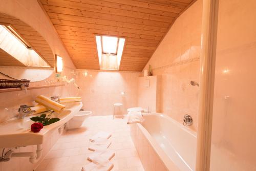 a bathroom with a tub and a toilet and a sink at Villa Rier in Siusi