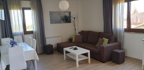 - un salon avec un canapé et une table dans l'établissement Apartamentos La Pradera de Isla, à Isla