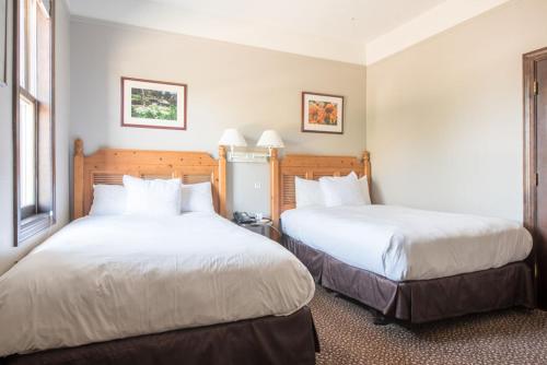 a hotel room with two beds and two windows at Elk Mountain Lodge in Crested Butte